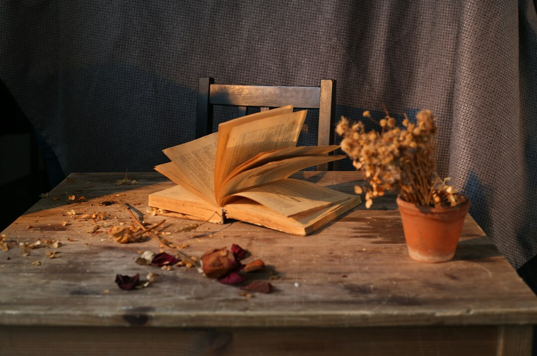 Wooden table covered with manuscript pages and a typewriter